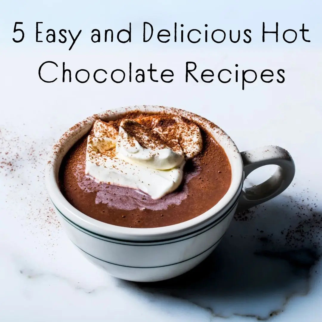 Mugs of hot chocolate topped with cream and chocolate
