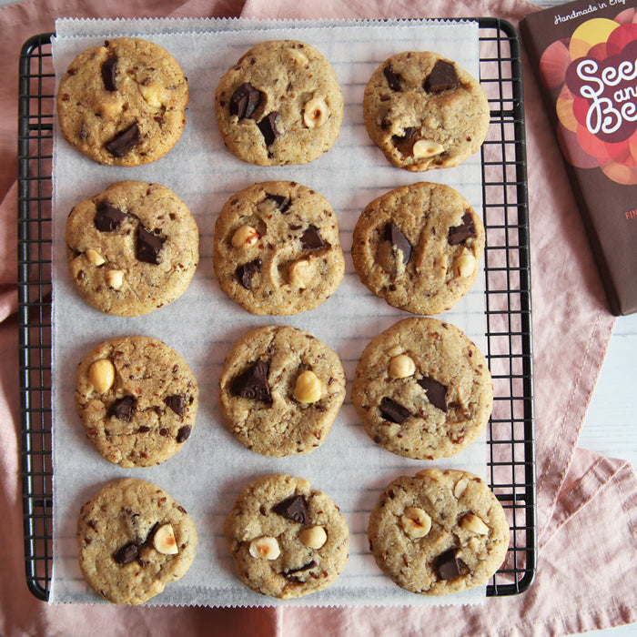 Dark chocolate chunk and hazelnut cookies on a rack