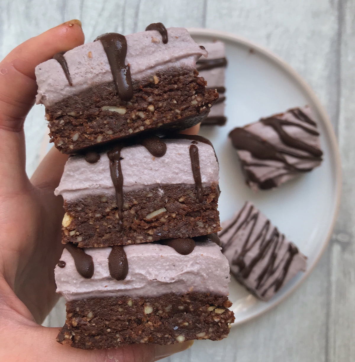 Raspberry brownie cheesecake bars drizzled with chocolate