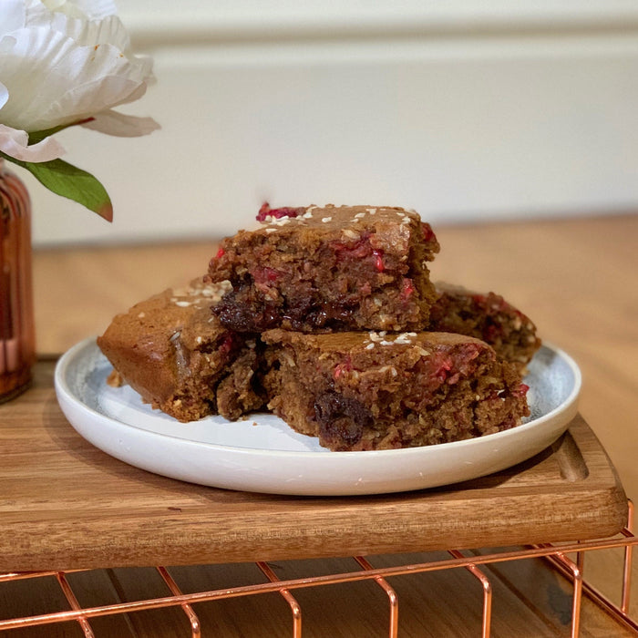 Gooey coconut and raspberry blondies on a board
