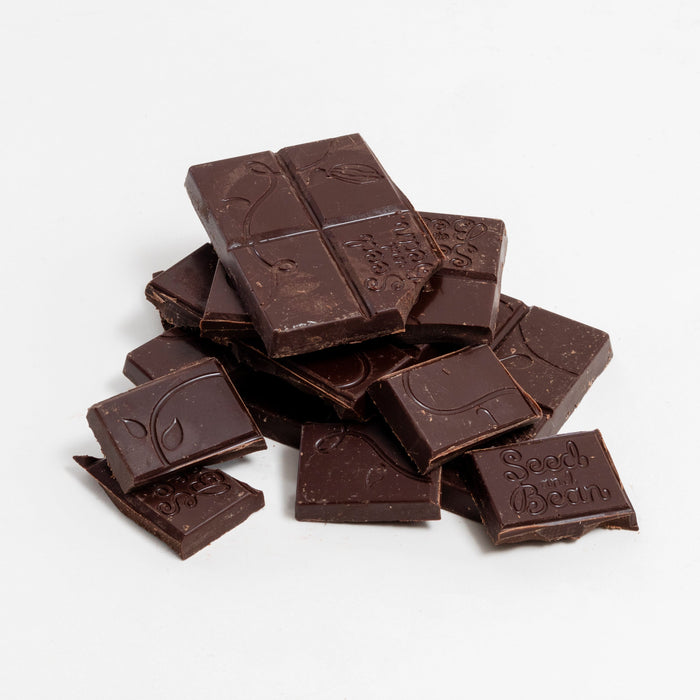 Person relaxing with a piece of dark chocolate