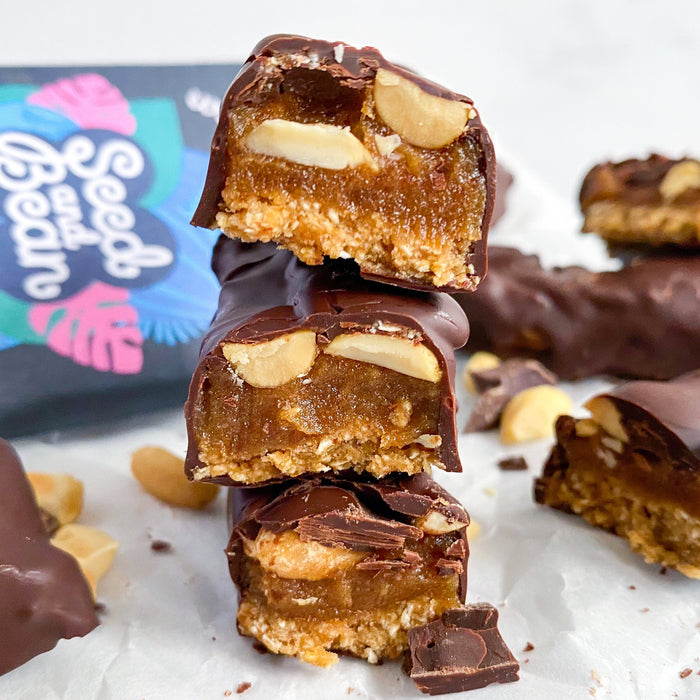 Homemade chocolate-coated caramel peanut bars cut into slices