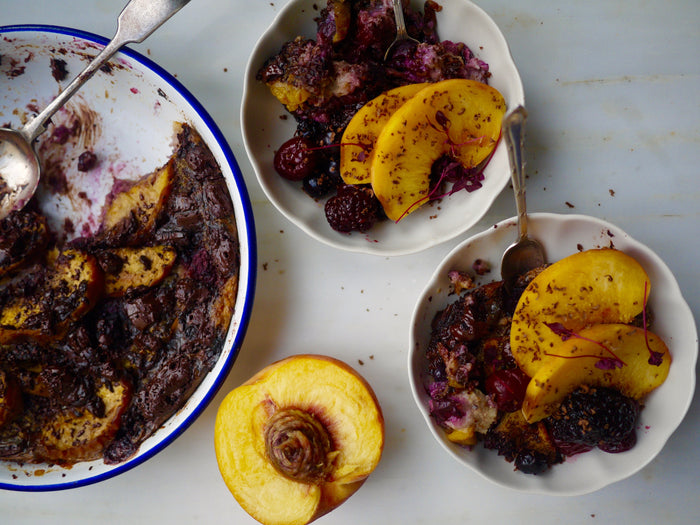 Baked oats with peaches, berries and chocolate in a dish