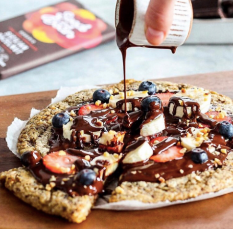 Dessert pizza topped with fresh fruit and melted chocolate
