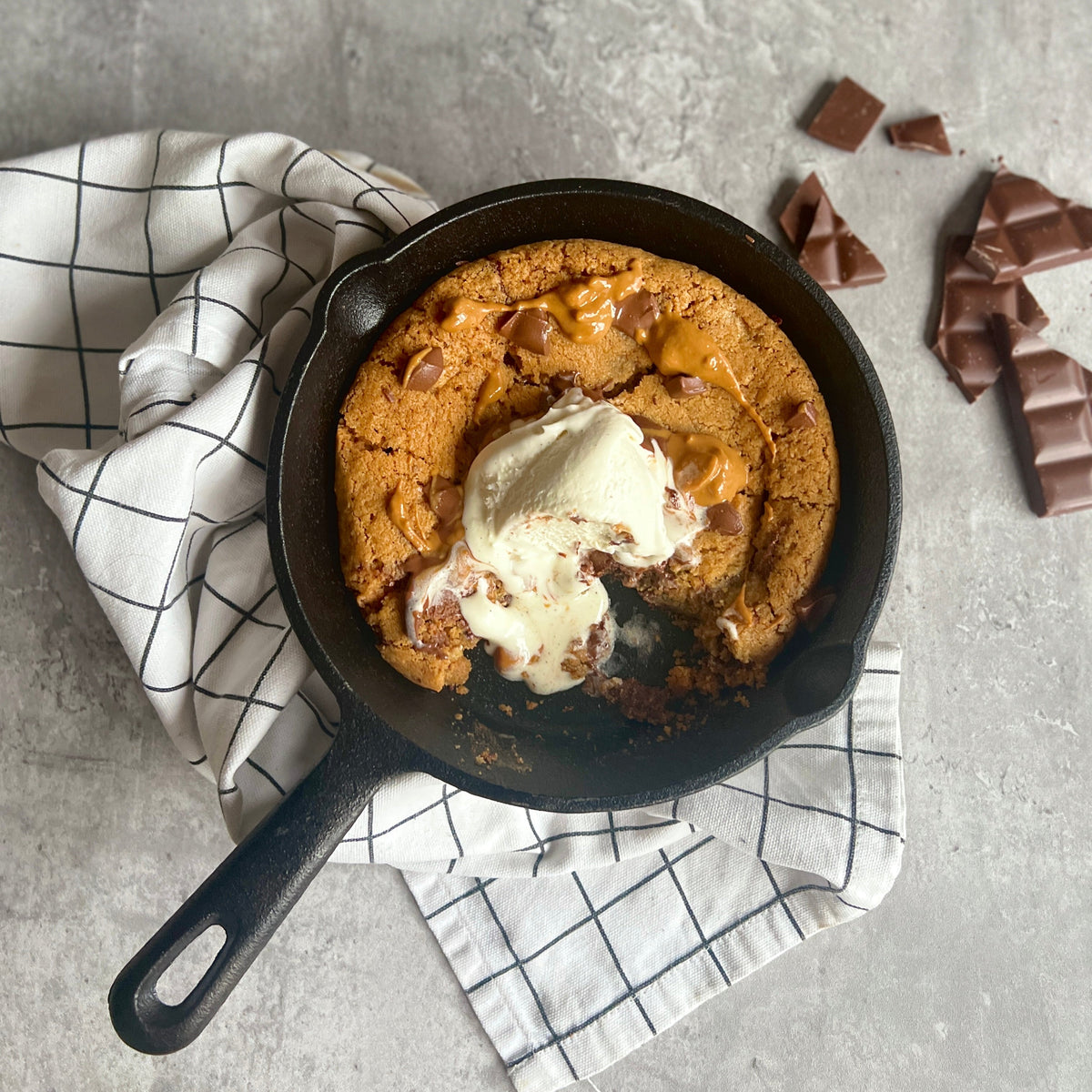 Plant-based chocolate chip cookie skillet in a cast iron pan