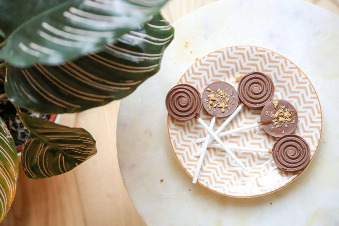 Homemade chocolate lollipops decorated with toppings