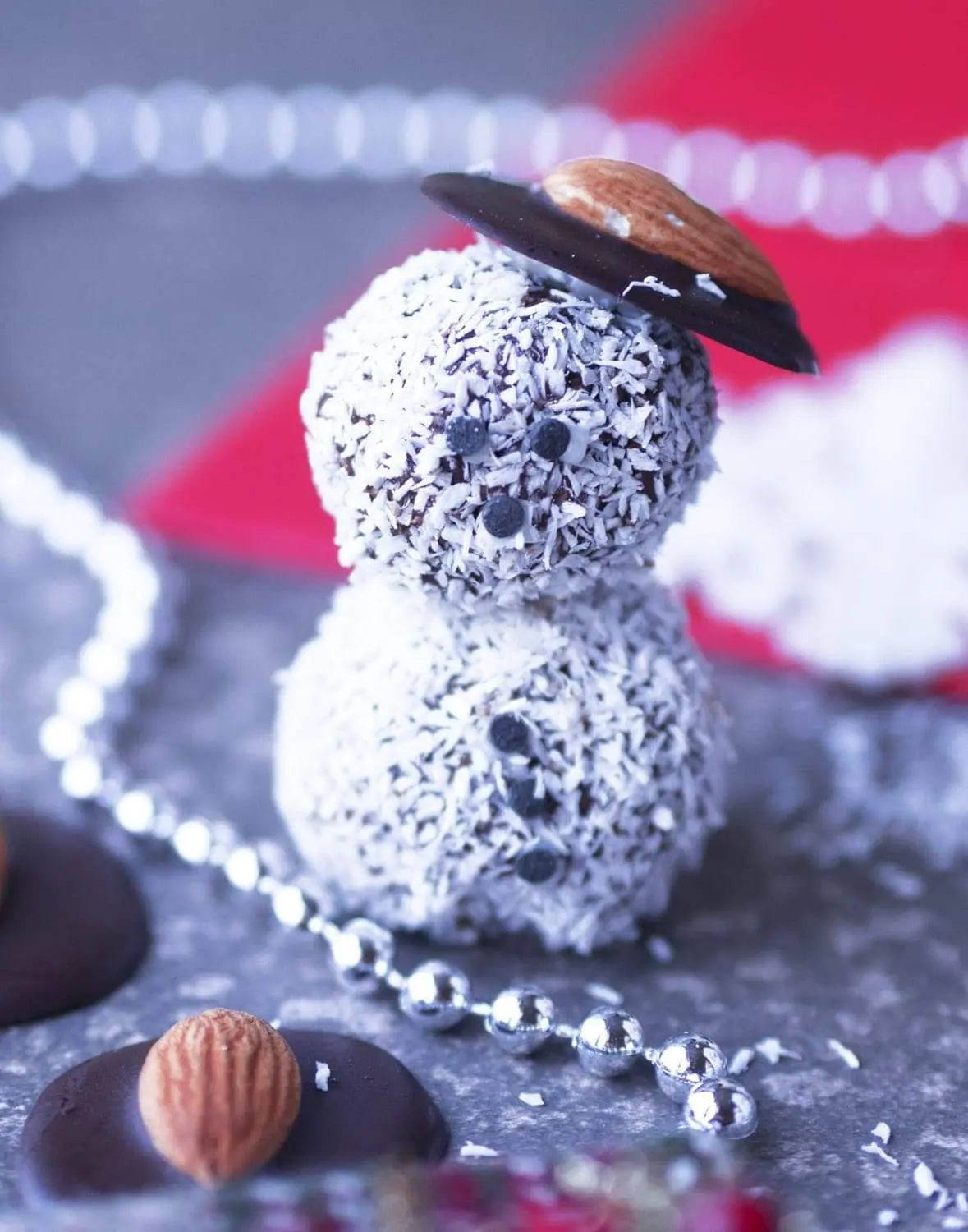 Vegan chocolate snowmen rolled in shredded coconut with almond hats
