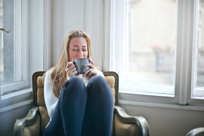 Person relaxing with a square of dark chocolate