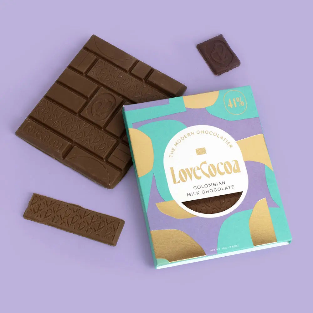 Love Cocoa Colombian Single Origin 41% Milk Chocolate Bar, pack with milk chocolate pieces on a lilac background