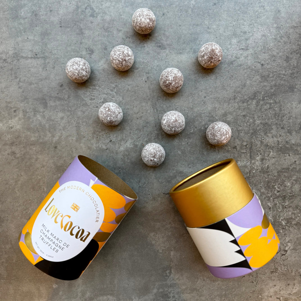 Love Cocoa Milk Chocolate Marc de Champagne Truffles, open truffle tube with truffles scattered