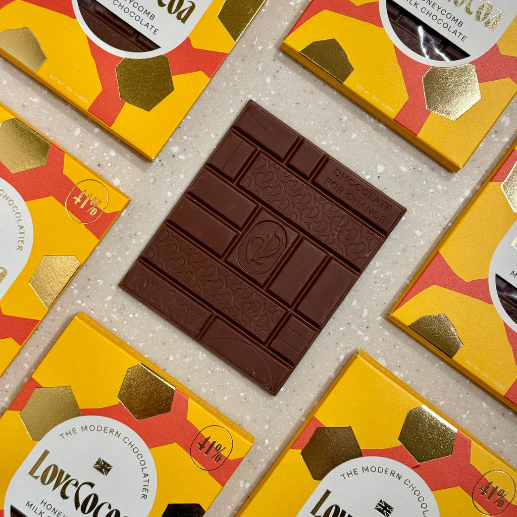 Love Cocoa Honeycomb 41% Milk Chocolate Bar, unwrapped milk chocolate bar on a stack of packs