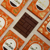 Love Cocoa Happy Birthday Honeycomb Milk Chocolate Bar, unwrapped bar on a stack of Happy Birthday packs