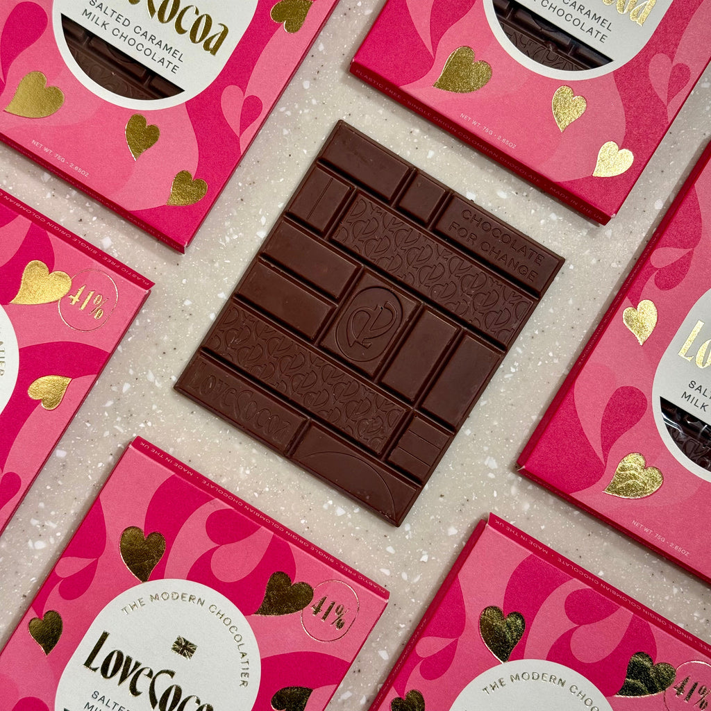 Love Cocoa Hearts Salted Caramel Milk Chocolate Bar, unwrapped milk chocolate bar on a stack of heart packs