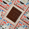Love Cocoa London Edition Colombian Milk Chocolate Bar, unwrapped milk chocolate bar on a stack of packs