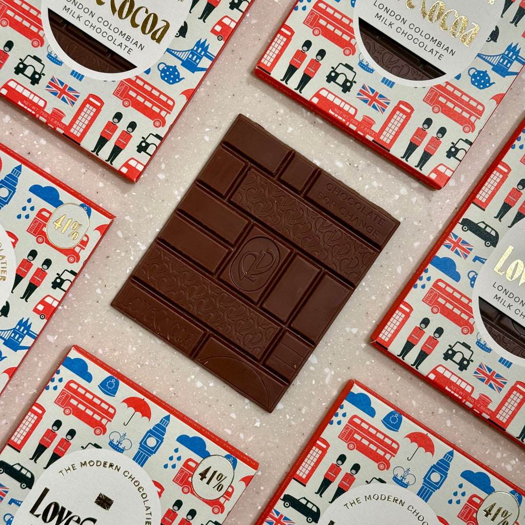 Love Cocoa London Edition Colombian Milk Chocolate Bar, unwrapped milk chocolate bar on a stack of packs