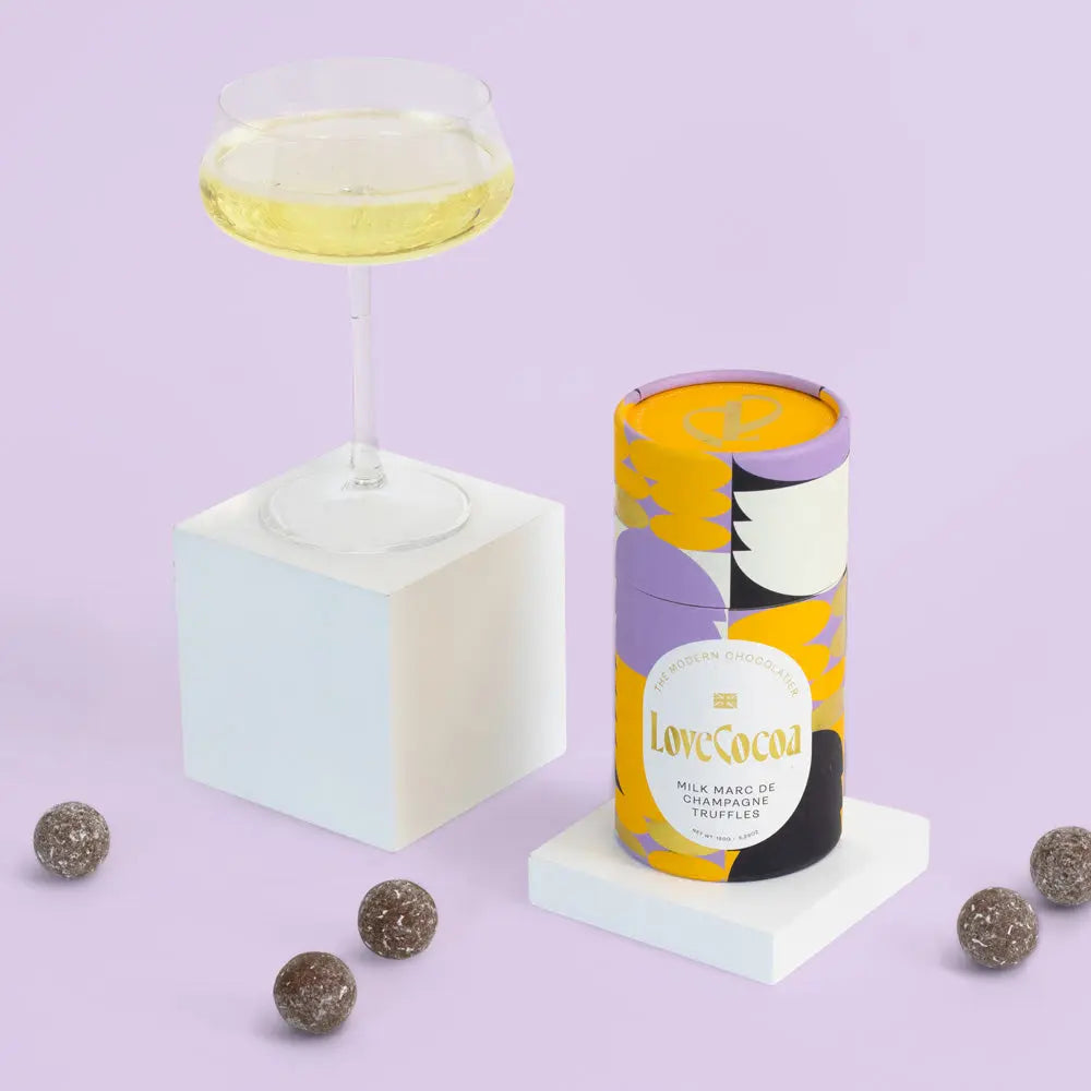 Love Cocoa Milk Chocolate Marc de Champagne Truffles, truffle tube with a glass of champagne and truffles