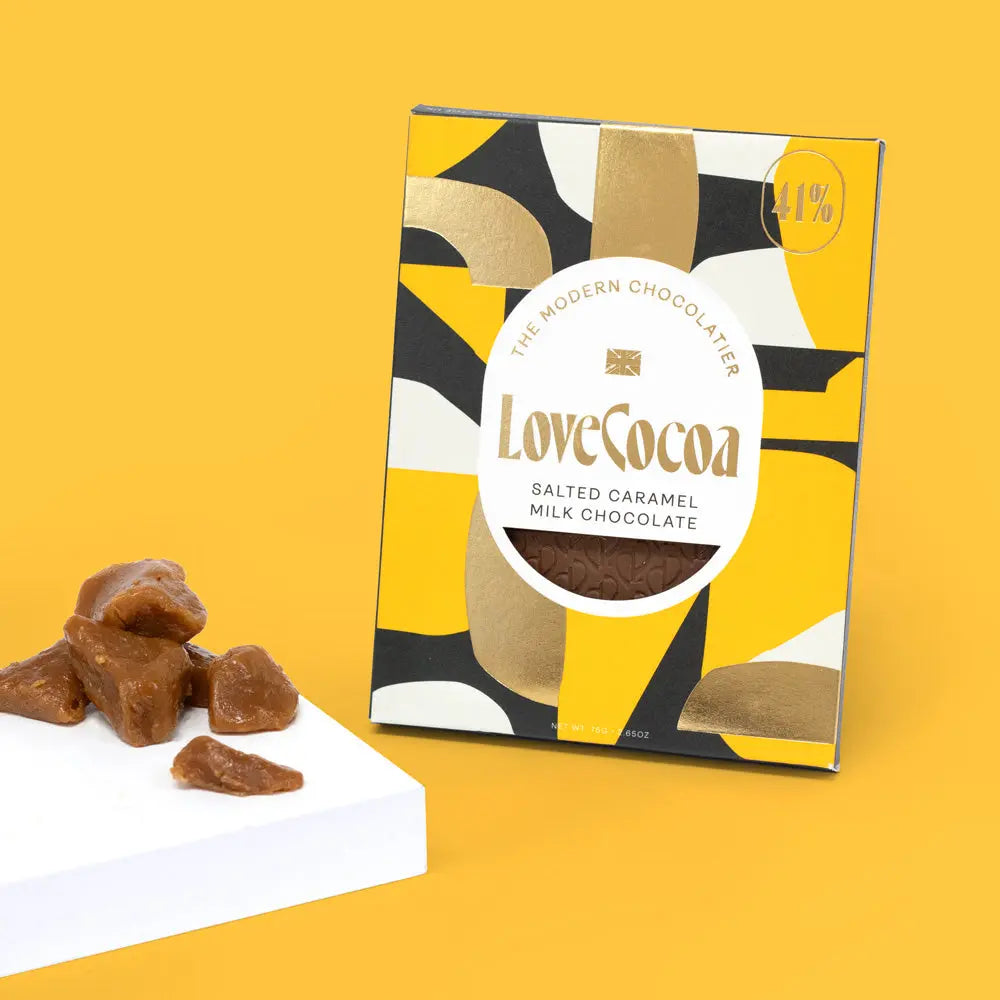 Love Cocoa Salted Caramel 41% Milk Chocolate Bar, pack with pieces of caramel on a yellow background