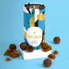 Love Cocoa Salted Caramel Milk Chocolate Truffles, truffle tube with truffles and caramel pieces on a blue background