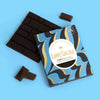 Love Cocoa Maldon Sea Salt Dark Chocolate Bar, pack with broken pieces of dark chocolate on a blue background