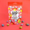 H!P Caramel Crunch Chocolate Peanuts, sharing pouch with coated peanuts on a red background