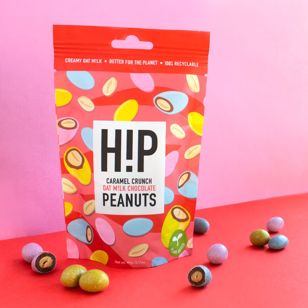 H!P Caramel Crunch Chocolate Peanuts, sharing pouch with coated peanuts on a pink and red background