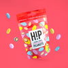 H!P Caramel Crunch Chocolate Peanuts, sharing pouch with coated peanuts on a red background
