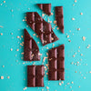 H!P Creamy Original Oat M!lk Chocolate bar, broken chocolate pieces with oat flakes on a turquoise background