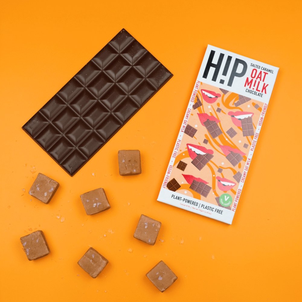 H!P Salted Caramel Oat M!lk Chocolate bar, wrapper with a bar and caramel pieces on an orange background