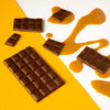 H!P Salted Caramel Oat M!lk Chocolate mini bar, chocolate pieces with caramel drizzle on a yellow background