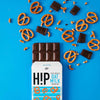 H!P Salty Pretzel Oat M!lk Chocolate bar, bar half out of its wrapper with pretzels