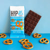 H!P Salty Pretzel Oat M!lk Chocolate mini bar, wrapper with a bar and pretzels on a blue background